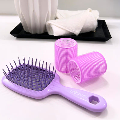 UNbrush Pastel Detangling Hair Brush in Lilac Purple laying on a table