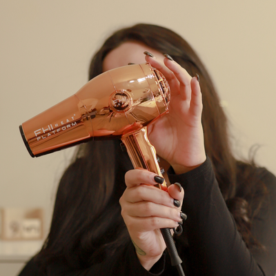 Model holding the Platform 1900 Rose gold Chrome Hair Dryer